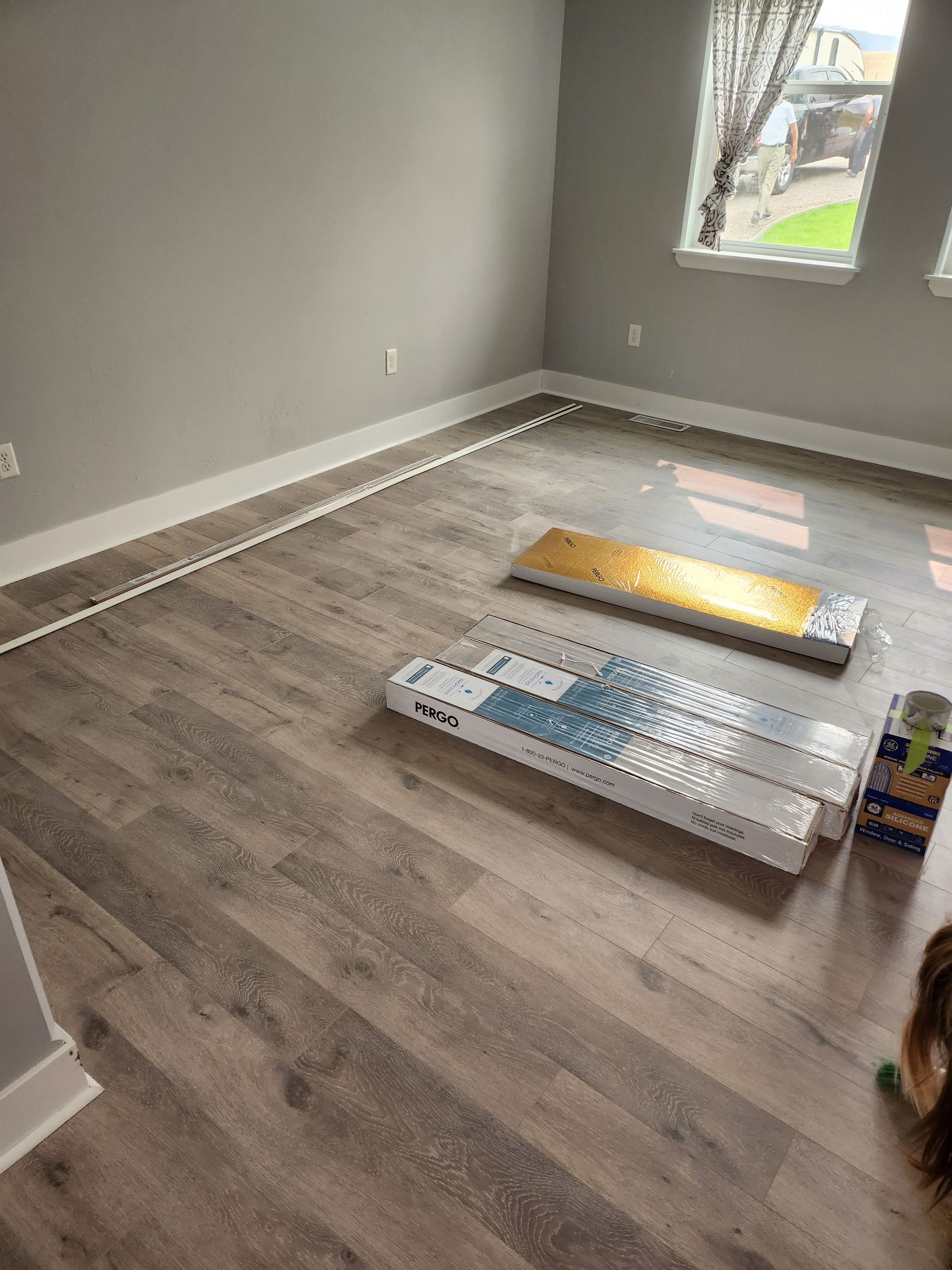 A room with a wooden floor and boxes on the floor.