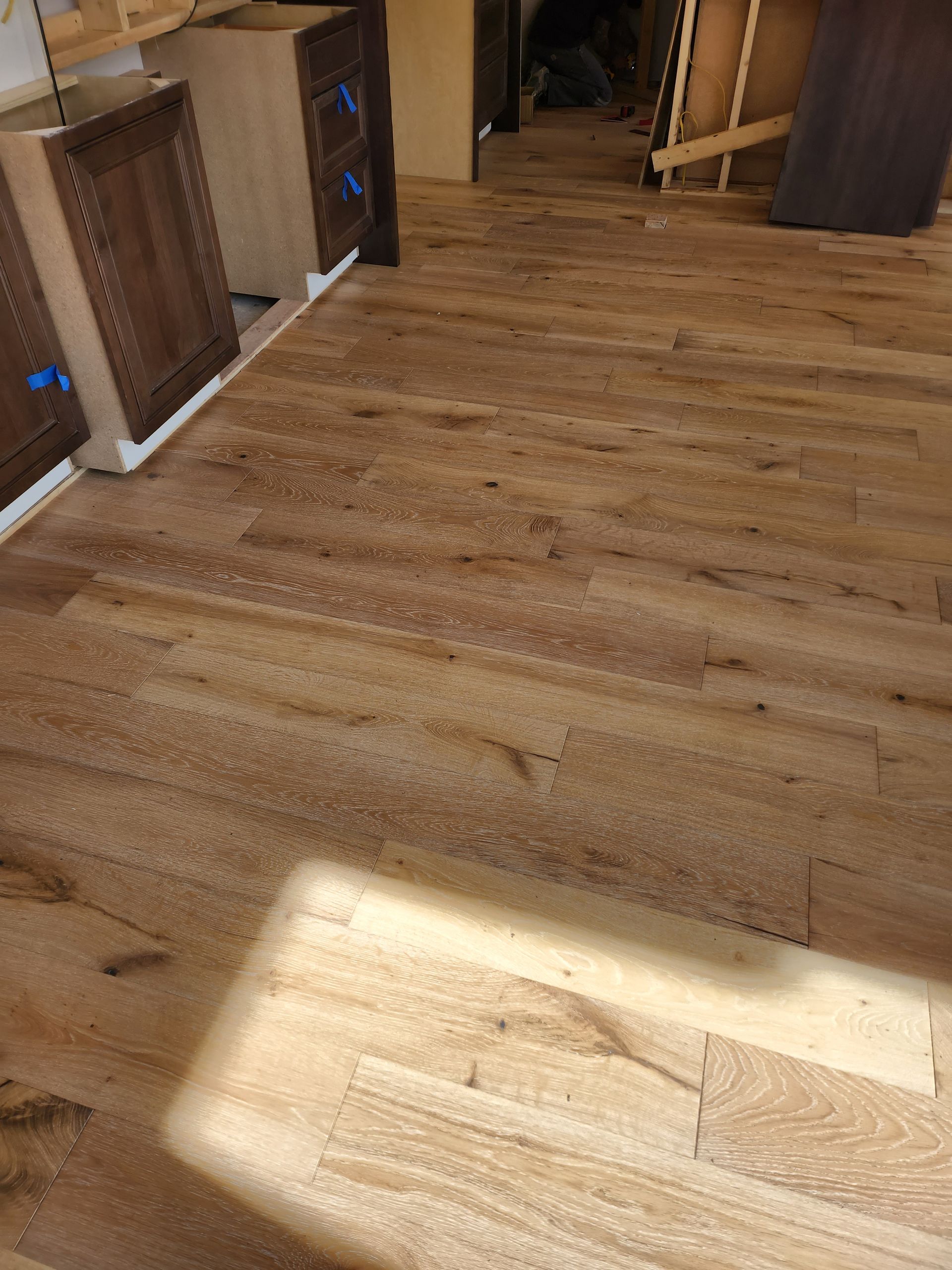 A kitchen with a wooden floor and cabinets in it.