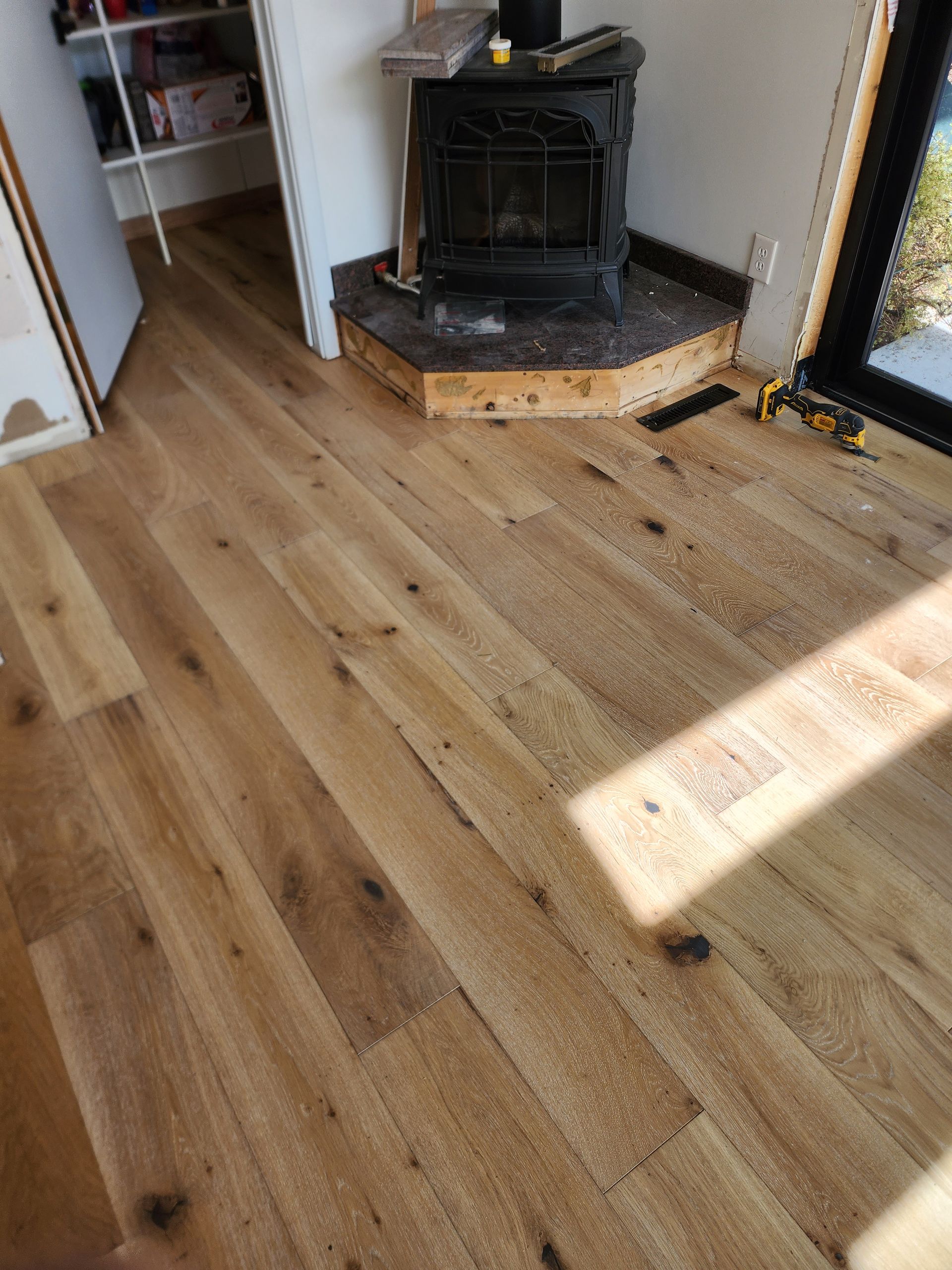 A wood stove is sitting on top of a wooden floor in a room.