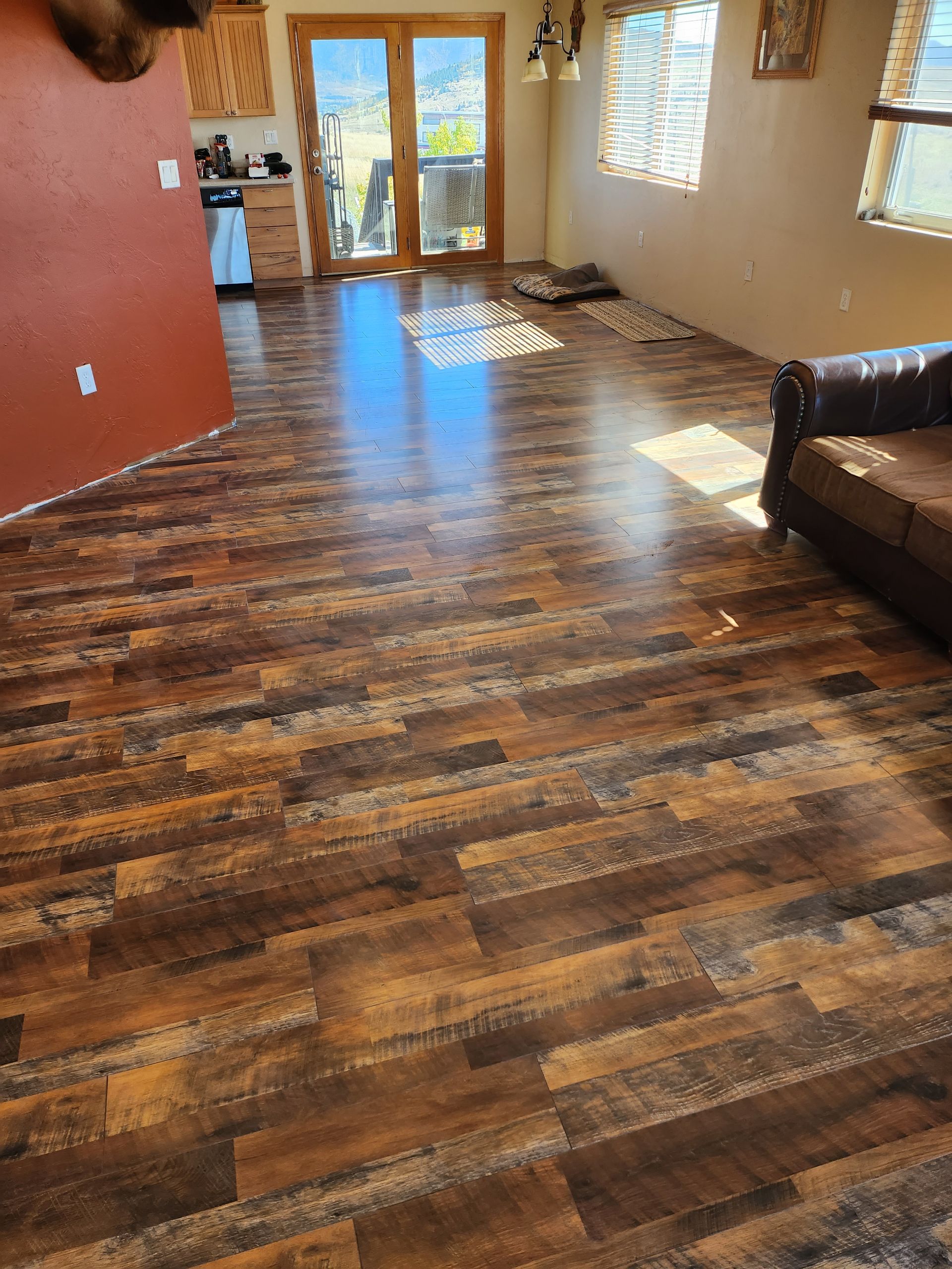 A living room with a wooden floor and a couch.