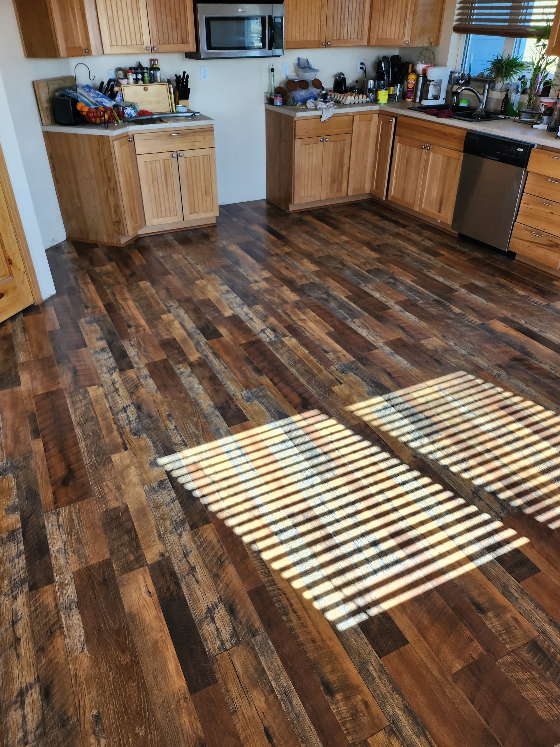 A kitchen with wooden floors and stainless steel appliances
