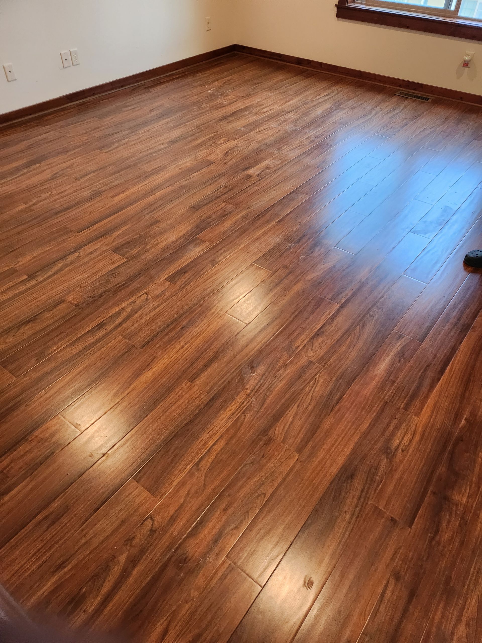 A room with a wooden floor and a window.