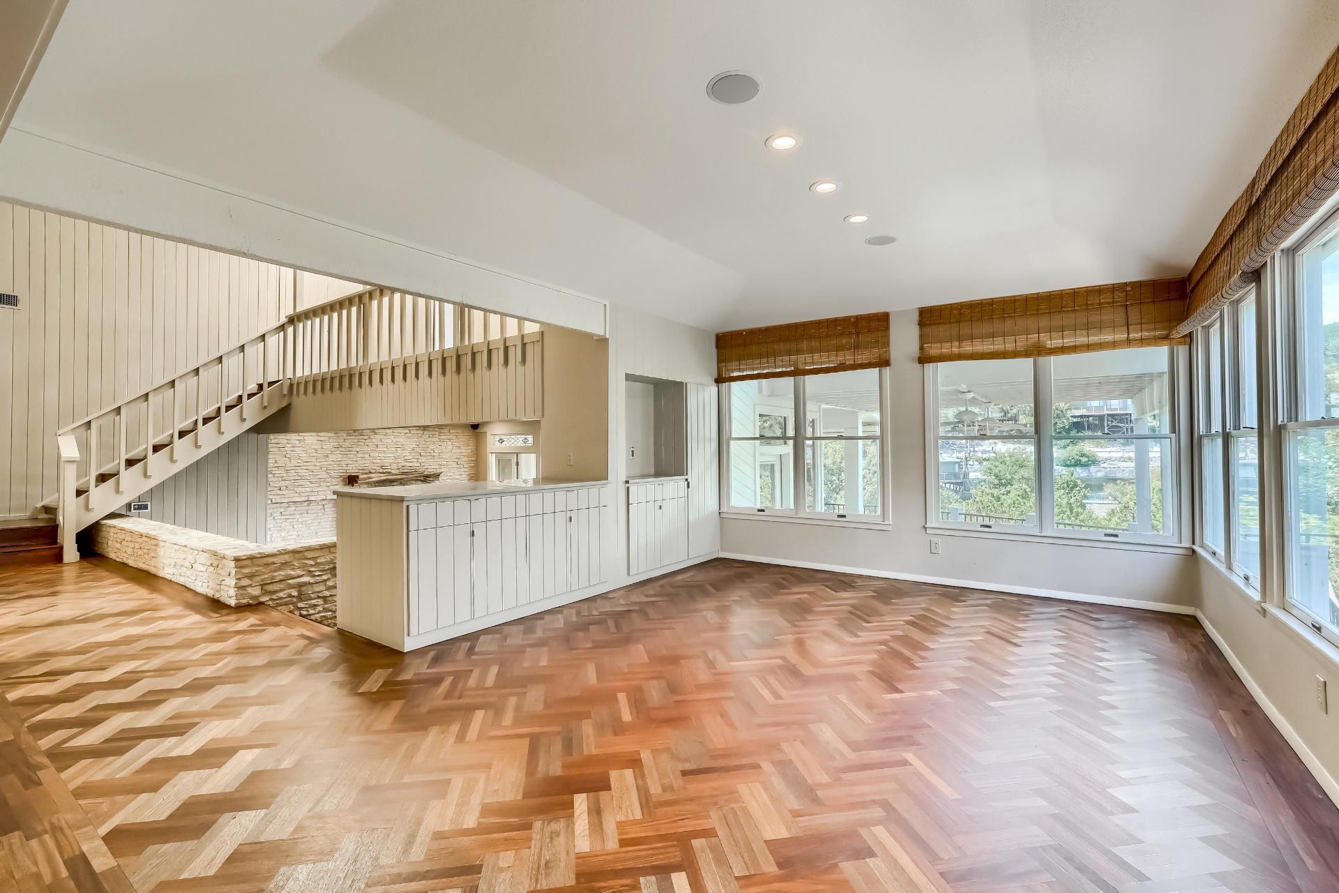A stylish luxury living room with expansive windows and staircase