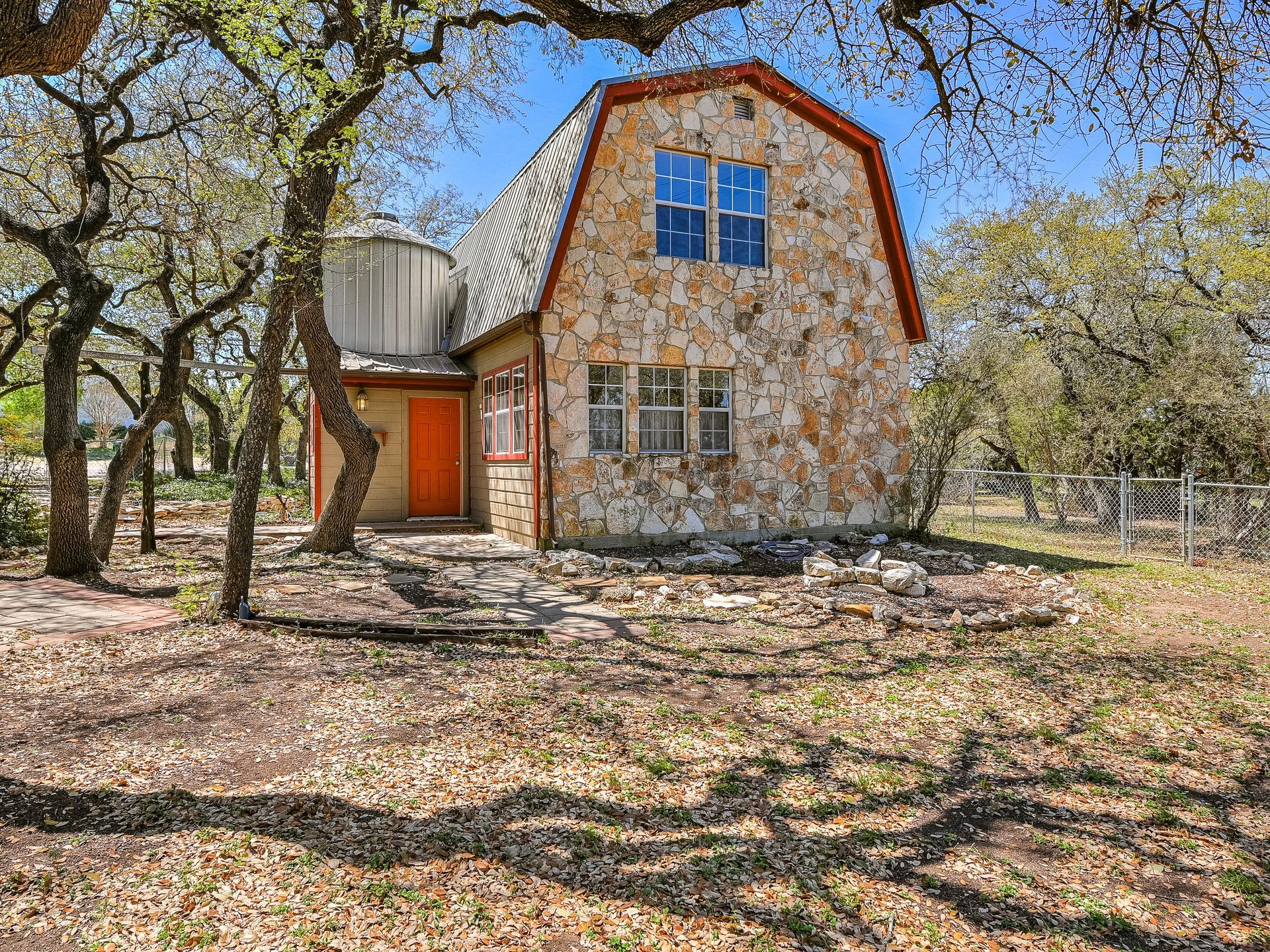 Exterior of a beautiful stone front home surrounded by lush greenery
