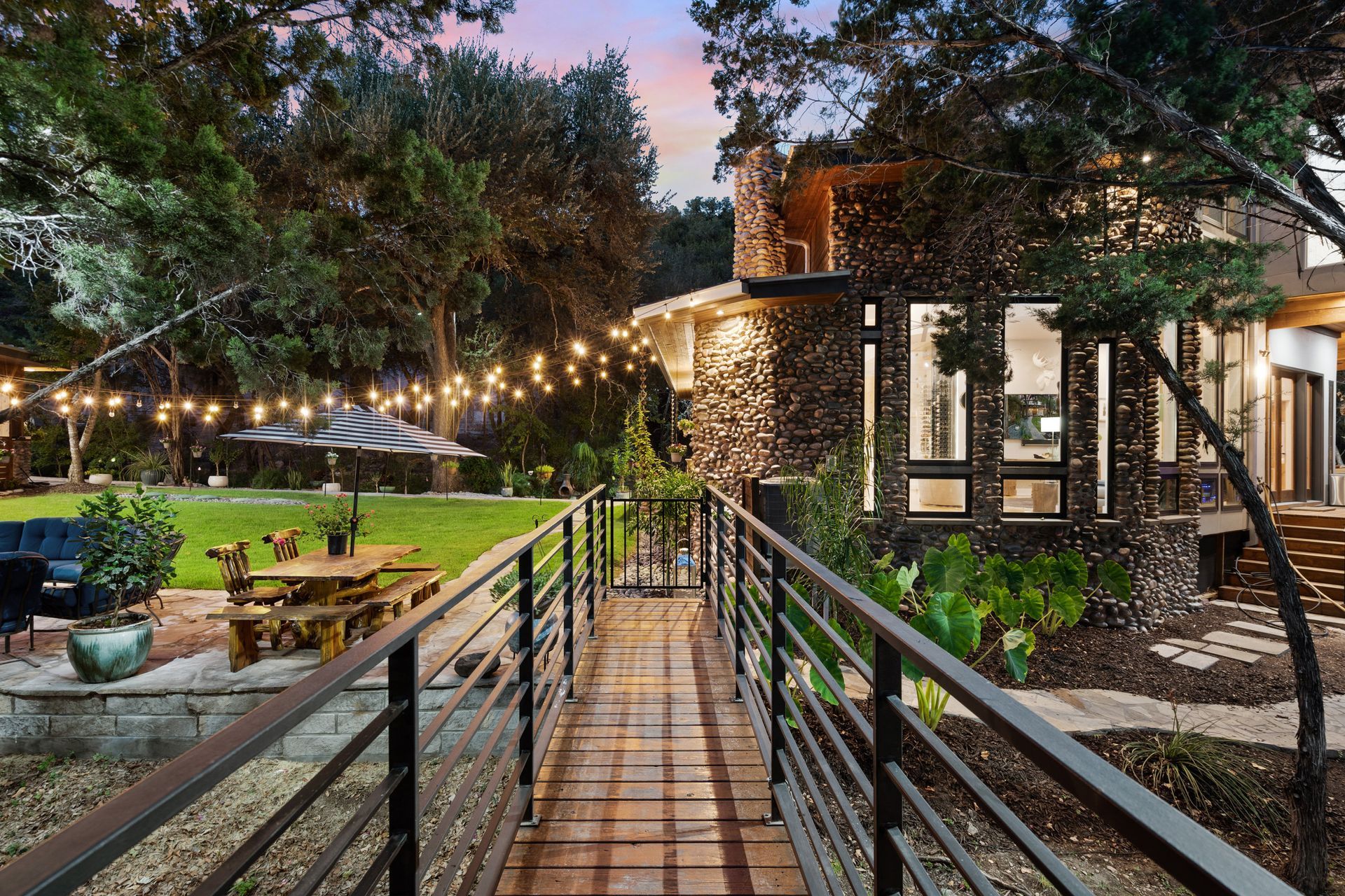 Charming home with a lovely backyard featuring an outdoor table and hanging lights