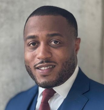 A man in a suit and tie is smiling for the camera.