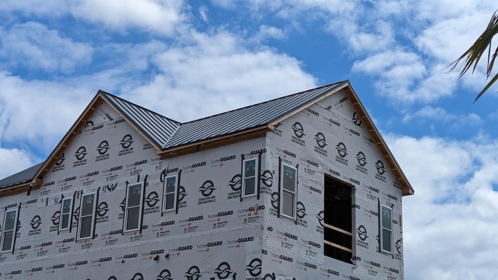 A house is being built with a blue sky in the background.