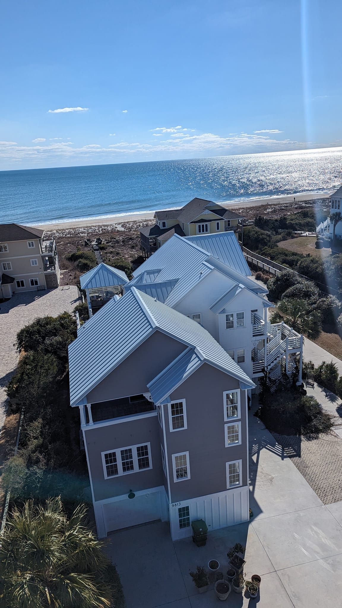 An aerial view of a house on the beach next to the ocean.
