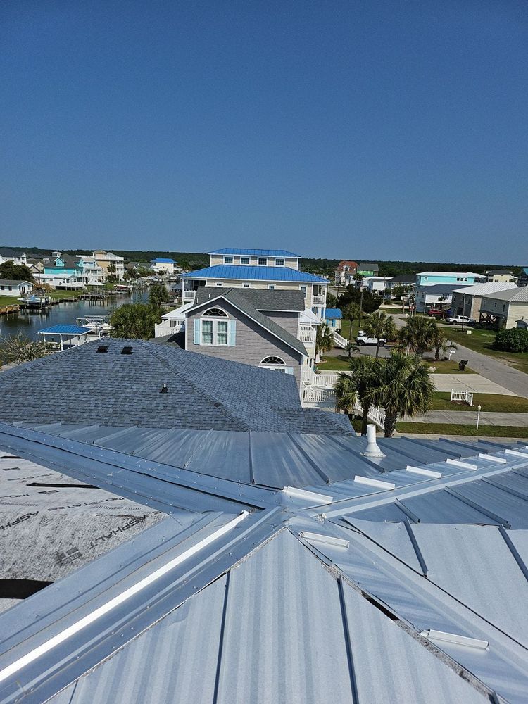 An aerial view of a roof with a few houses in the background