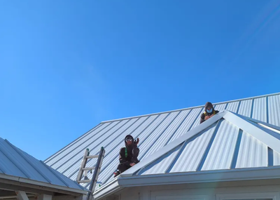 Two men are working on the roof of a house.