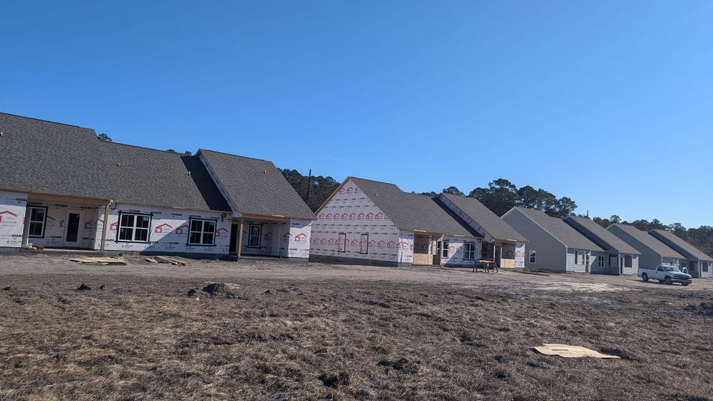 A row of houses are being built in a field.
