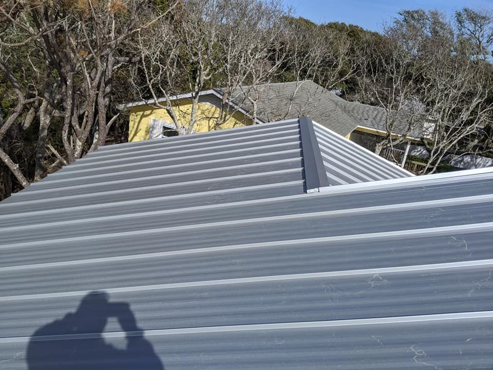 A person is taking a picture of the roof of a house.