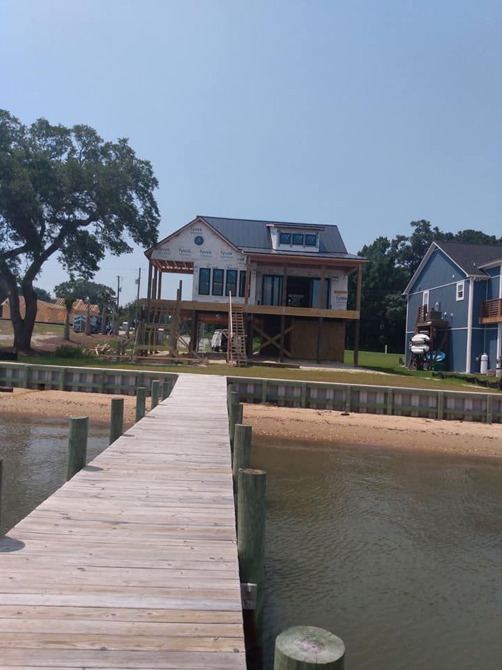 A wooden dock leads to a house on the shore