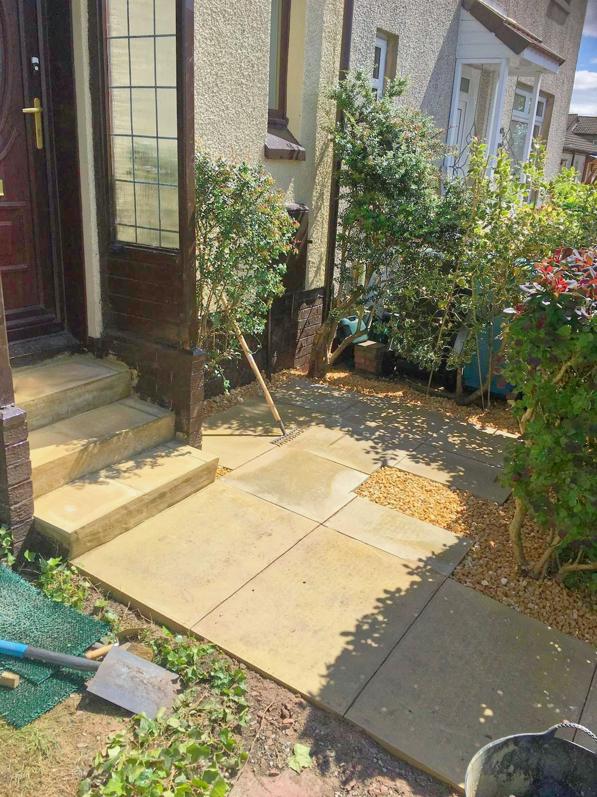 New slabs leading up to repaired concrete steps in front of a house.