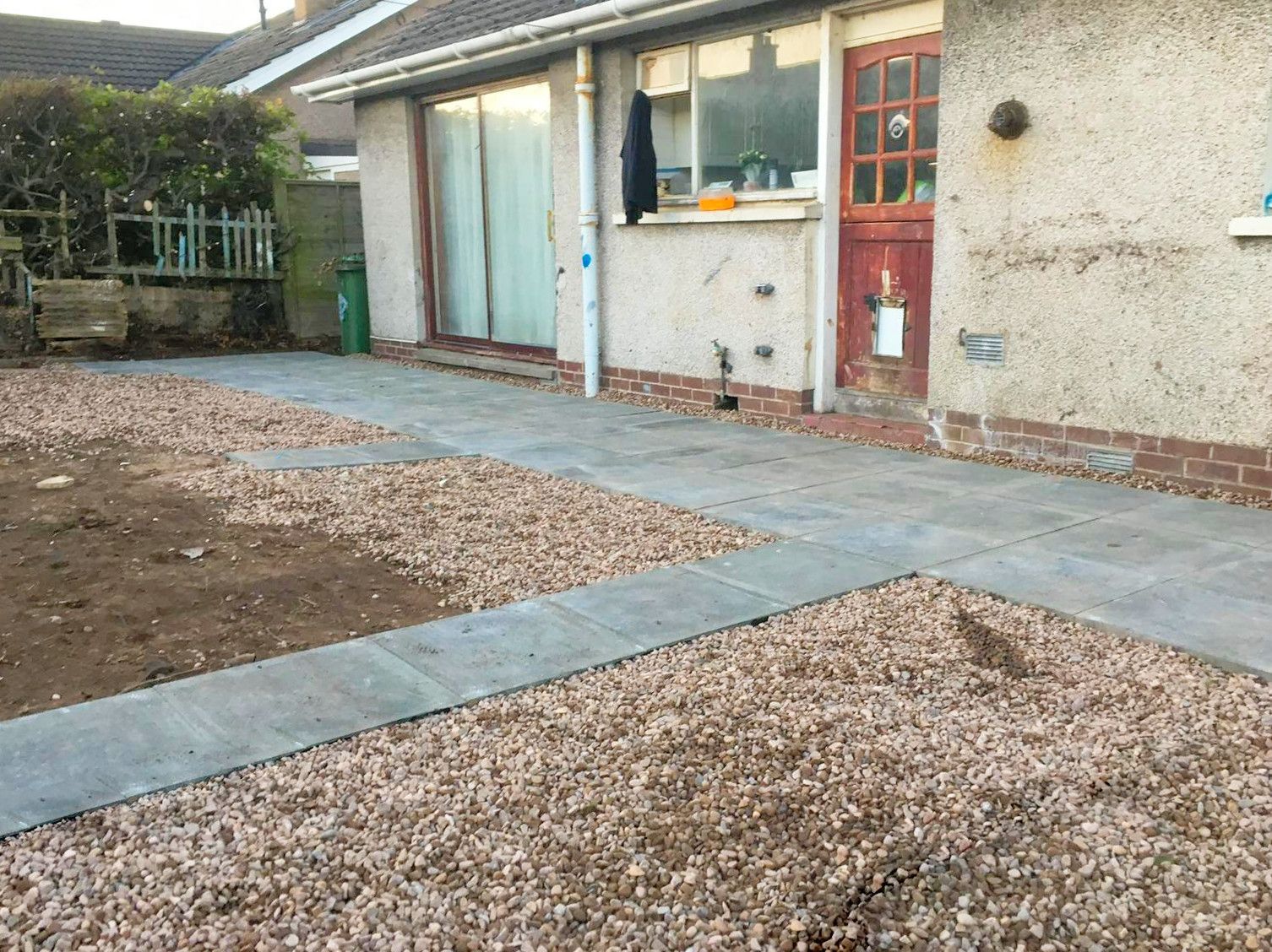 A house with a gravel driveway in front of it.