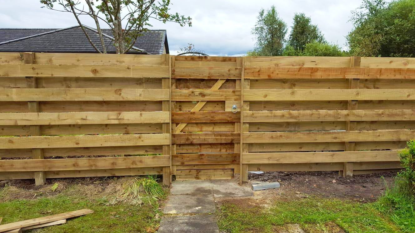 A wooden fence with a gate in the middle of it.