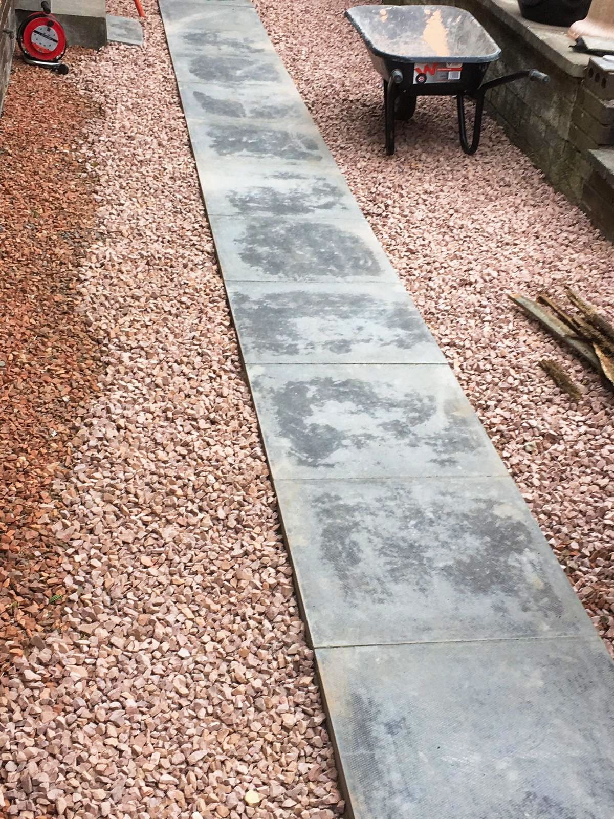 A long walkway surrounded by gravel. 