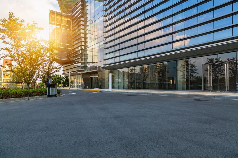 An empty parking lot in front of a tall building.