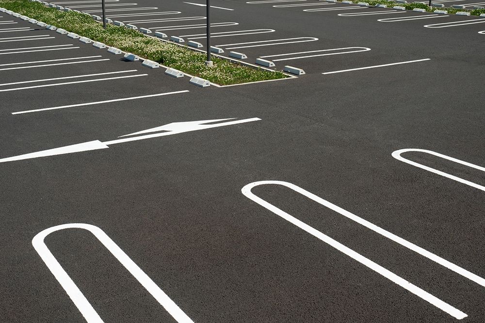 A parking lot with white lines and arrows on it