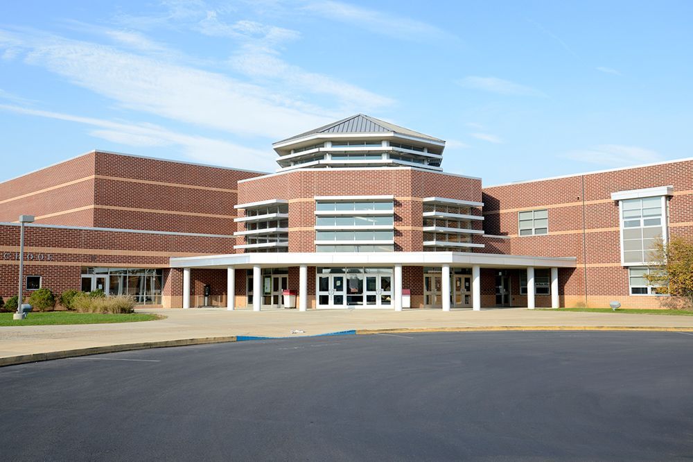 A large brick building with a lot of windows and a blue sky in the background.
