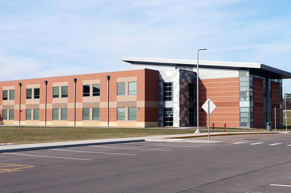 A large brick building with a parking lot in front of it