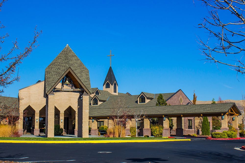 A church with a steeple and a cross on top of it.