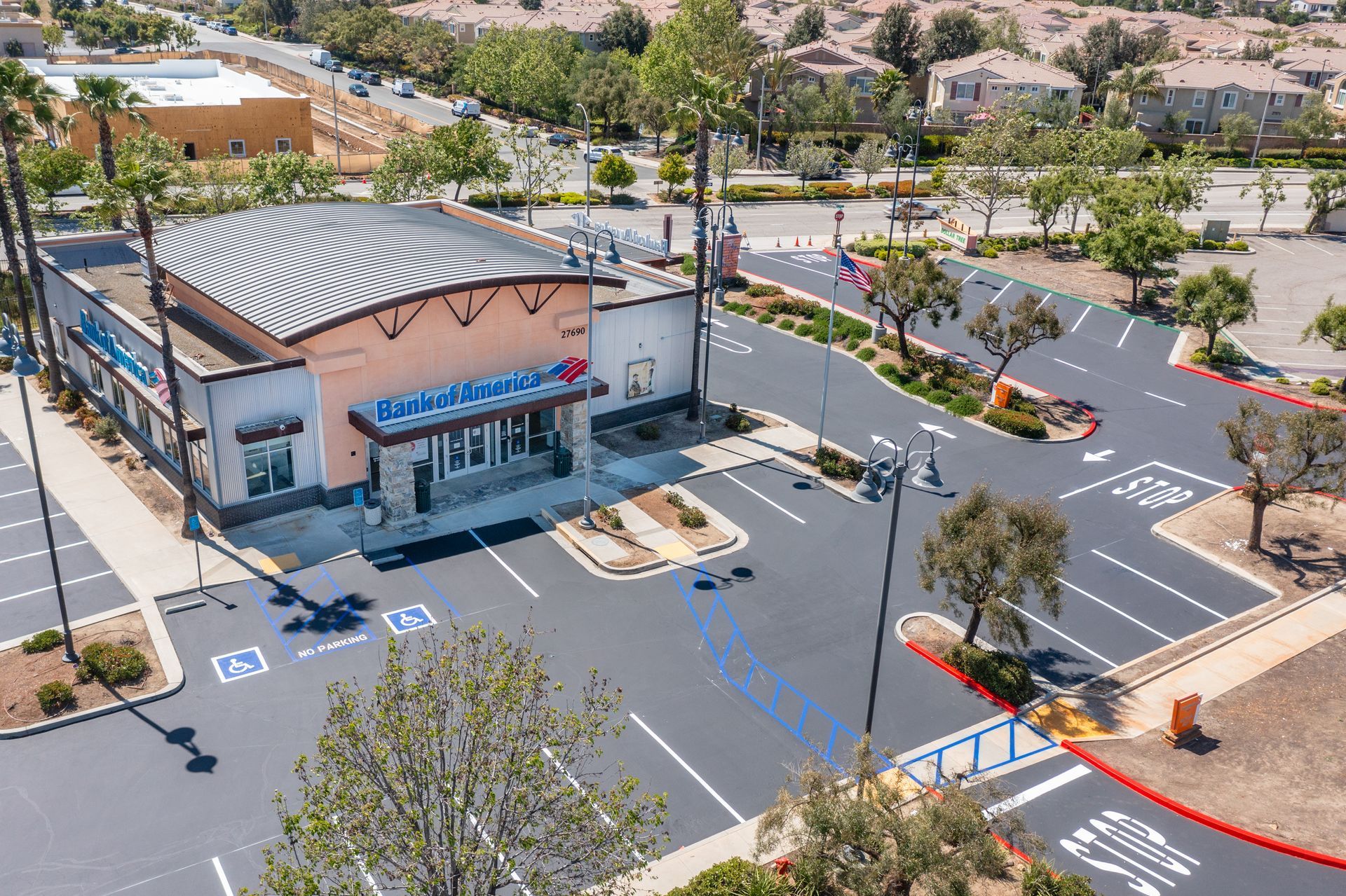 An aerial view of a store with a parking lot in front of it.