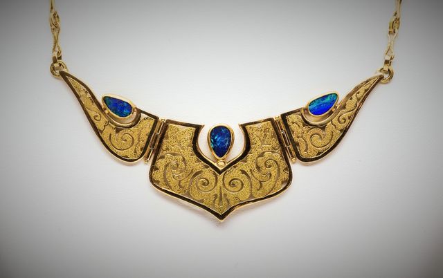 collier d'oro con tre pietre blu