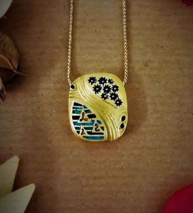 ciondolo d'oro rettangolare con decorazioni blu