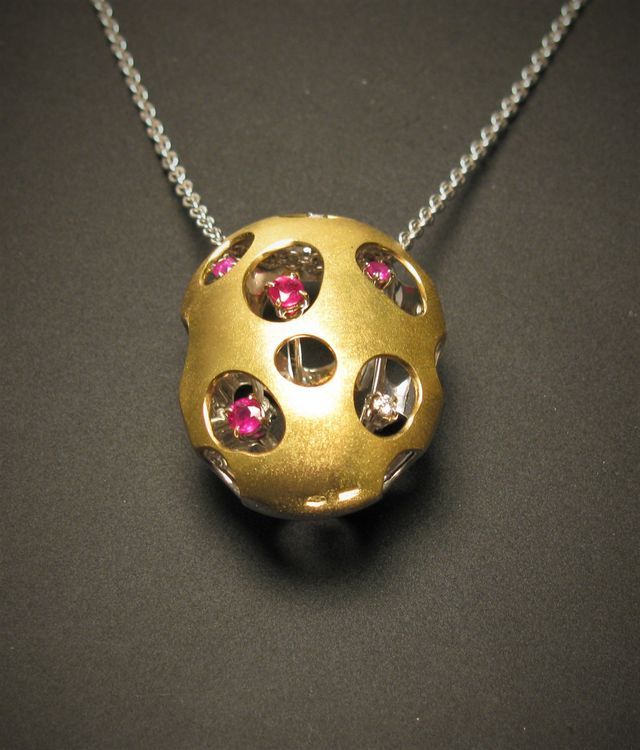 ciondolo d'oro forato con pietre all'interno