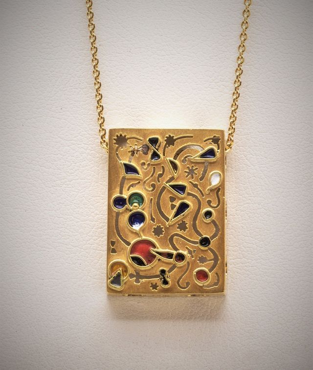 ciondolo d'oro rettangolare con piccole pietre preziose colorate