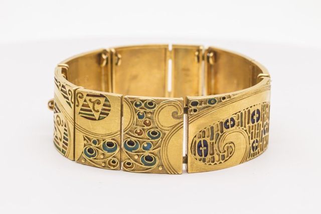 bracciale alto in oro con decorazioni astratte sinuose