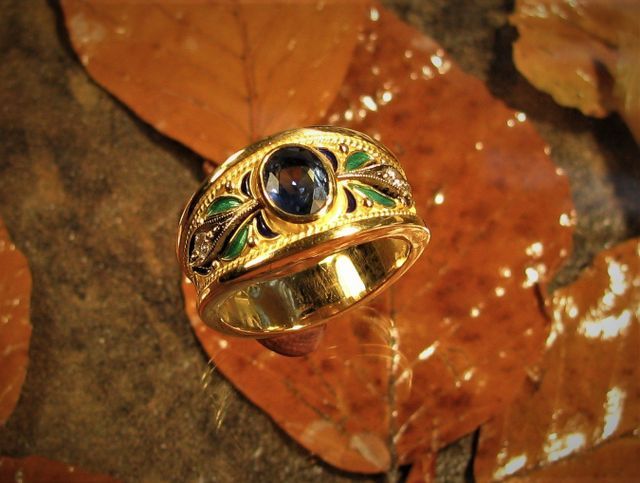 anello d'oro con fregi e pietra centrale