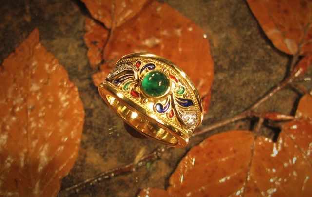 anello in oro con fregi e pietra preziosa centrale