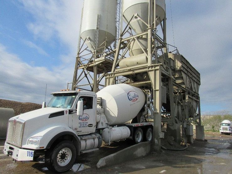white concrete mixing truck filling up