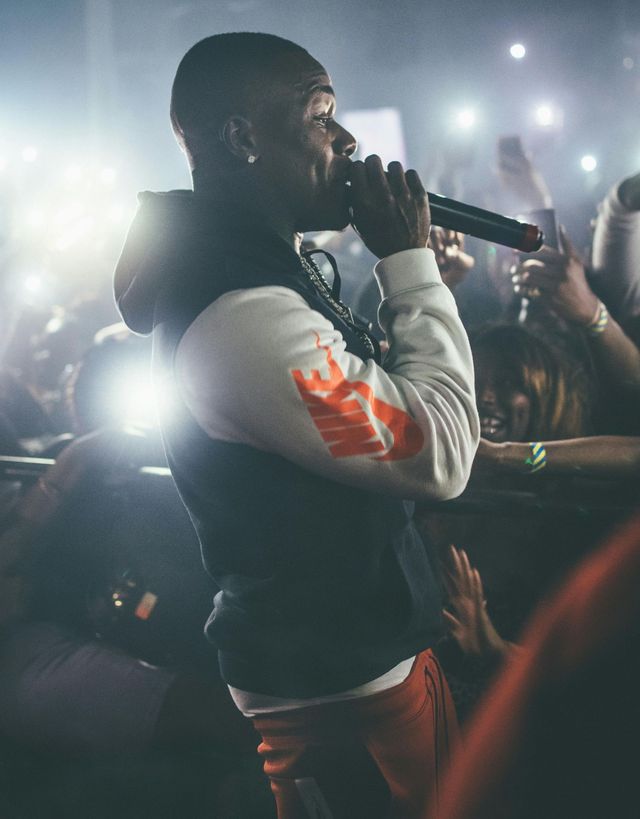 A man is singing into a microphone in front of a crowd.