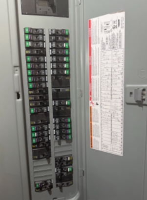 Open electrical control panel featuring neatly organized rows of breakers, relays, and yellow and white wiring.