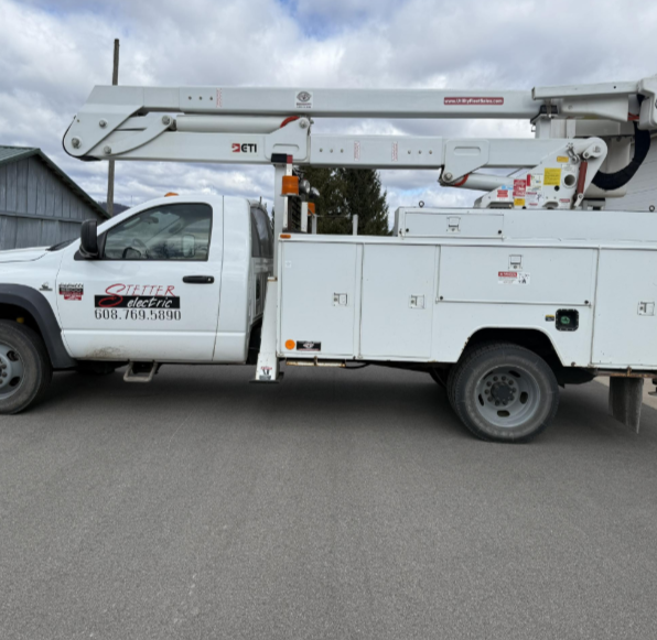 A person holds a clipboard and pen while inspecting an open residential electrical breaker panel.
