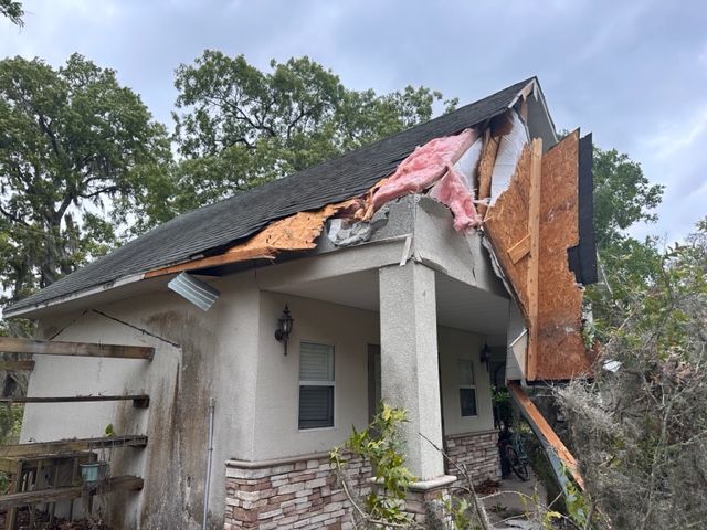 A house with a roof that has been damaged by a storm