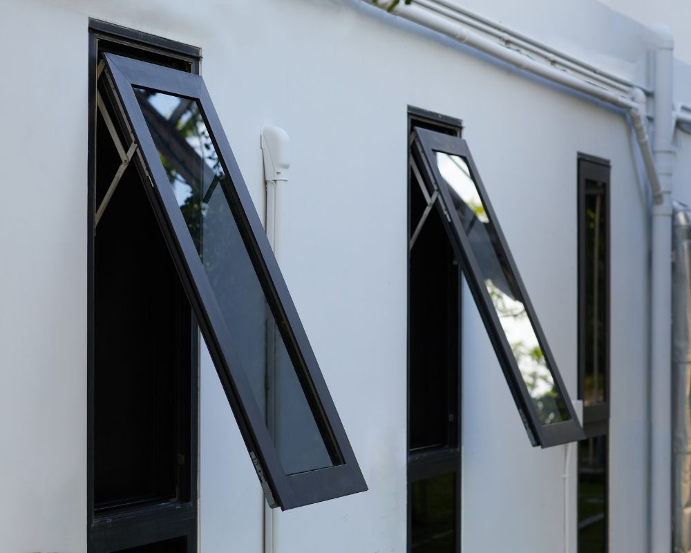 A white building with black windows that are open