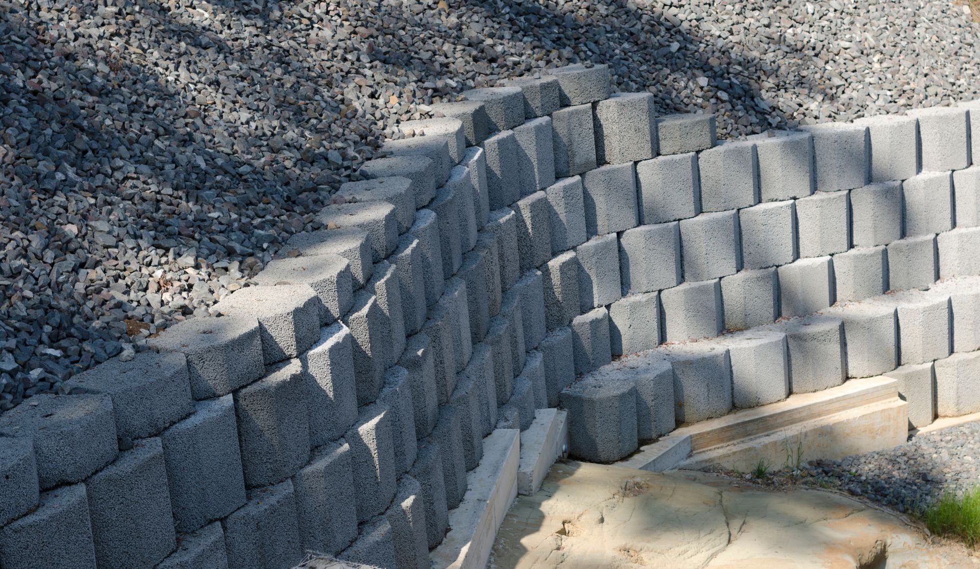 A brick wall is being built on top of gravel