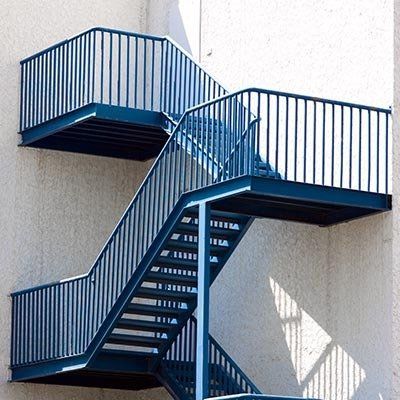 Blue steel fire escape against a white wall