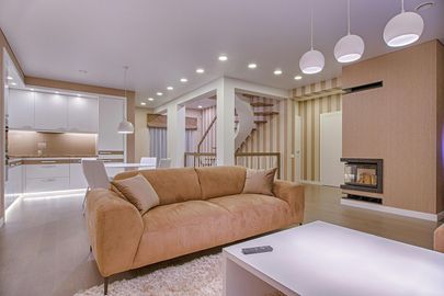 A living room with a chair , lamp , shelf and potted plant.