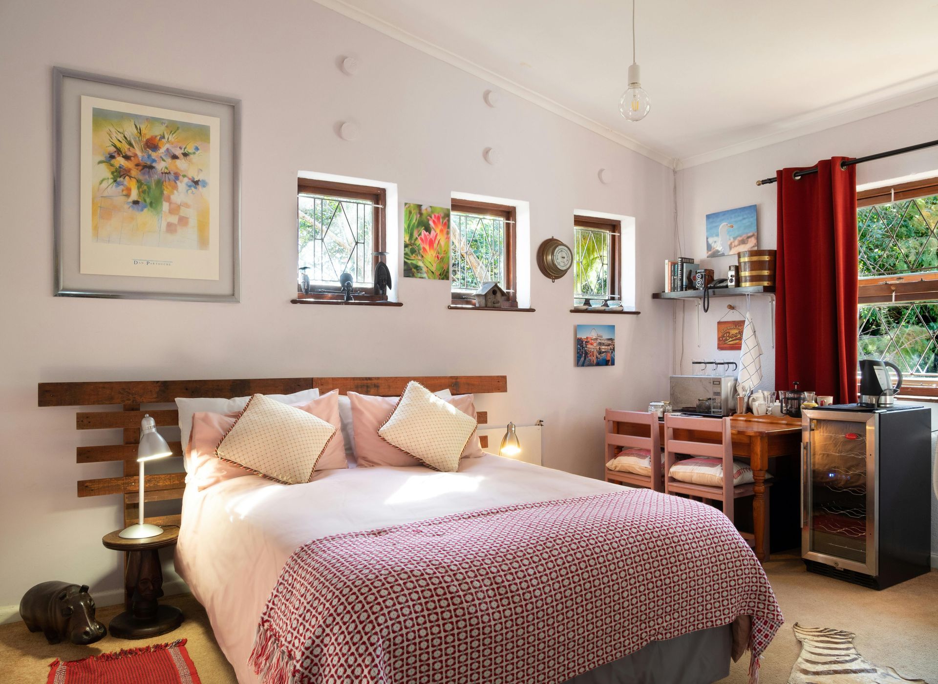 A bedroom with a king size bed and a wine cooler
