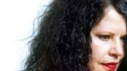Close-up profile of a person with curly black hair and red lipstick against a white background