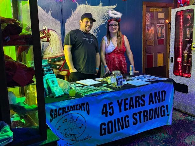 Two people behind a blue booth banner reading “45 YEARS AND GOING STRONG!”