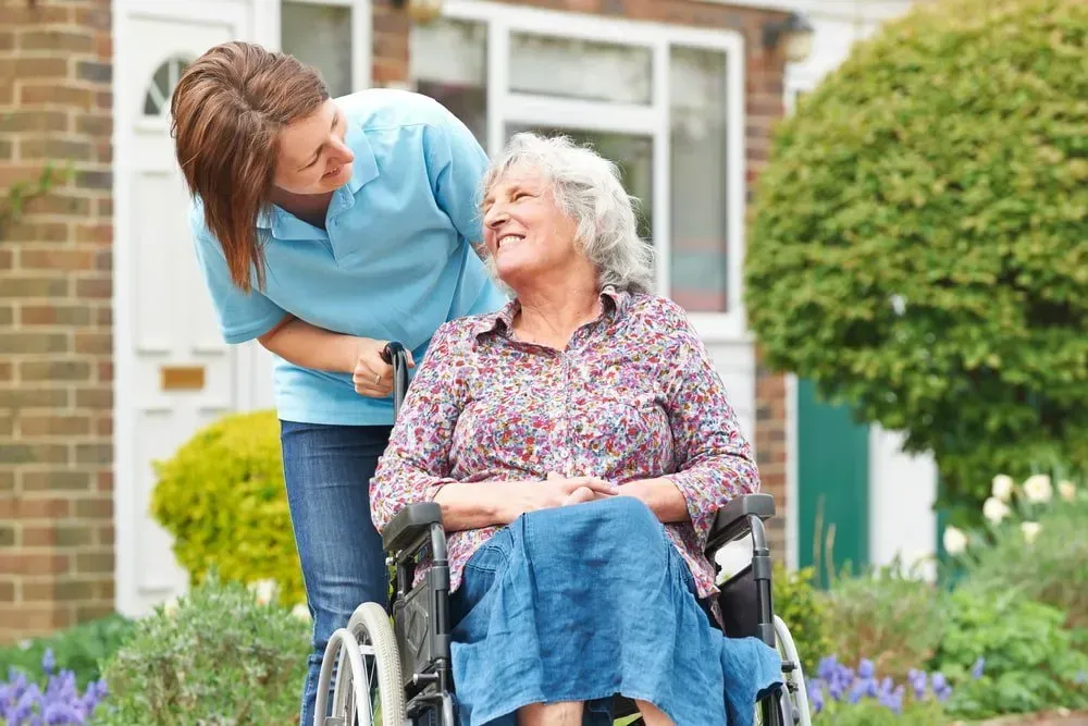 Caregiver in a Blue Polo Shirt Smiles — CQ Home Care in Yeppoon, QLD
