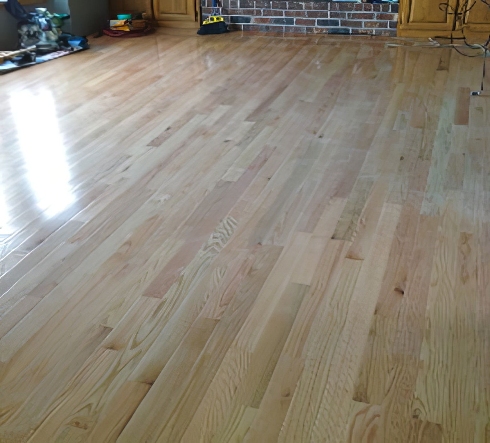 Light-colored hardwood floor in a room, with a glossy finish.