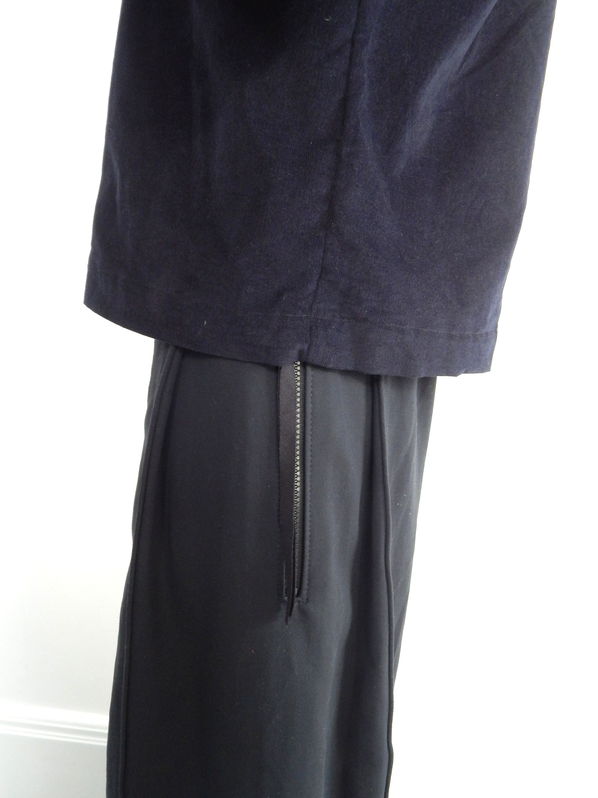 Navy blue jacket over black pants with a zipper detail.