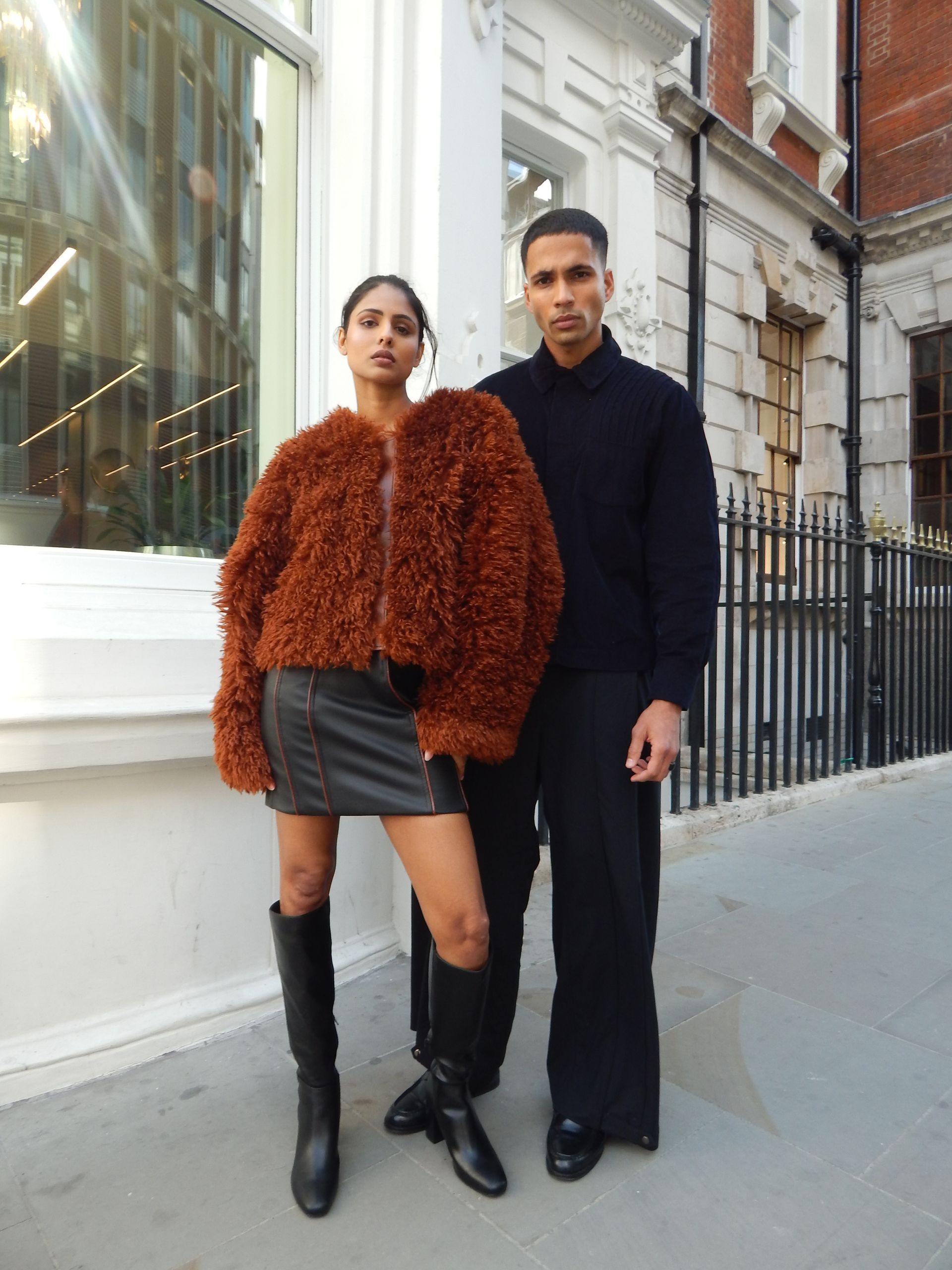 Person kneeling on a yellow couch wearing blue leggings and yellow heels.